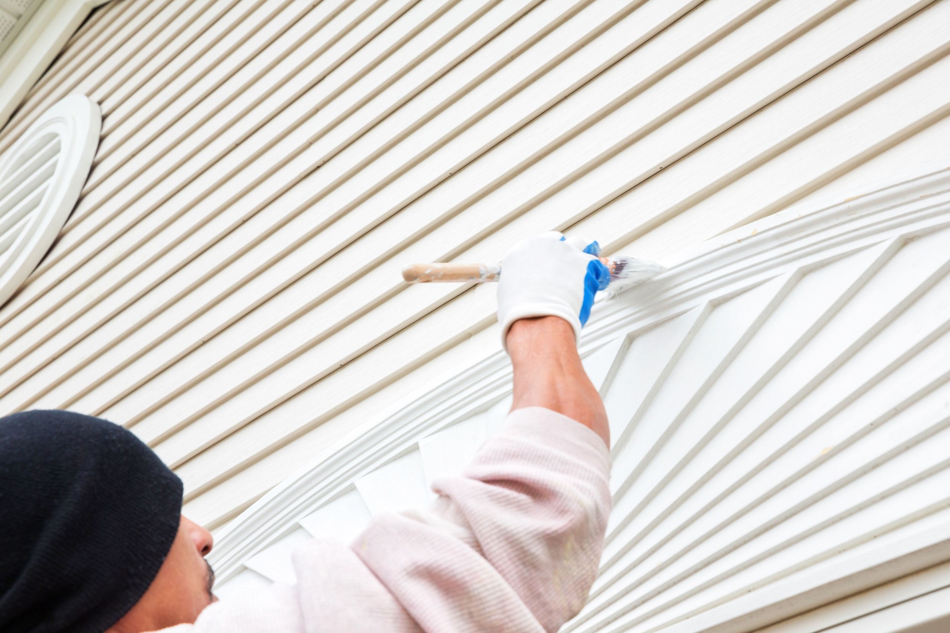 Painter paints the outside of a residential home