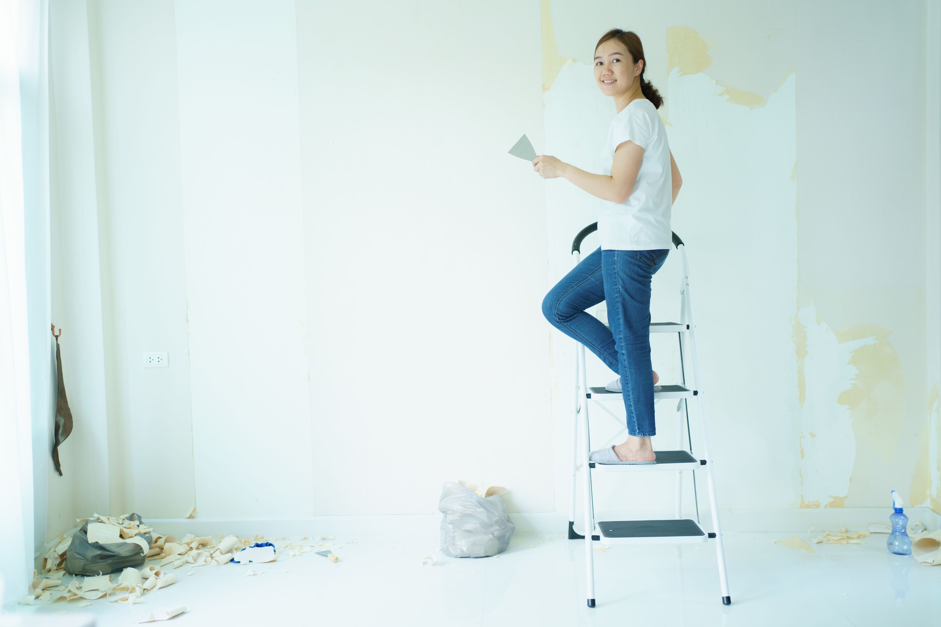 Woman fixing cracked wall.